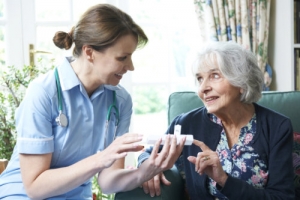 nurse advising elderly woman on taking medication